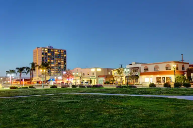 Chula Vista city park at sunset with buildings and green lawn