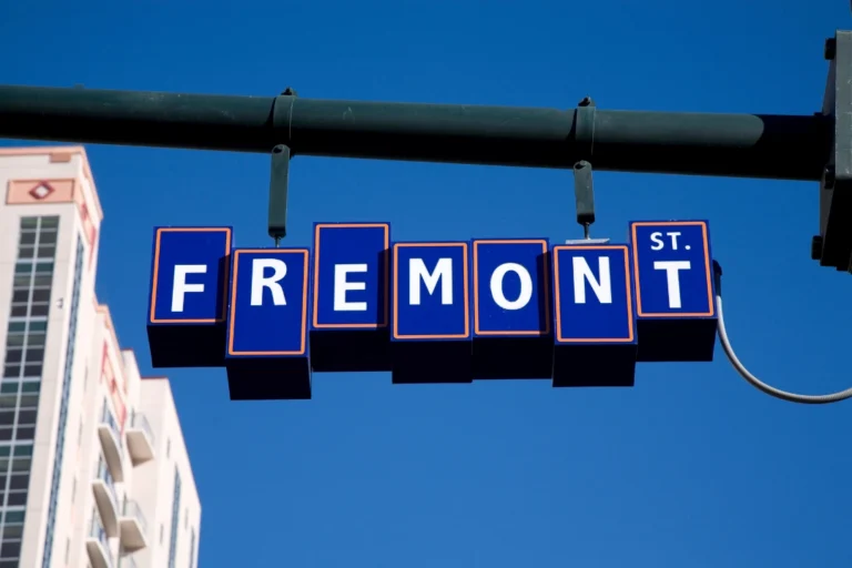 Close-up of the iconic Fremont sign with blue block letters hanging against a clear blue sky.