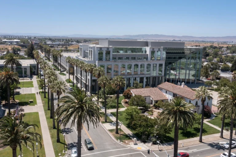 Aerial view of Fairfield, CA featuring a modern civic building, palm-lined streets, surrounding greenery, and distant hills. Tower 25 digital marketing experts creating business growth strategies